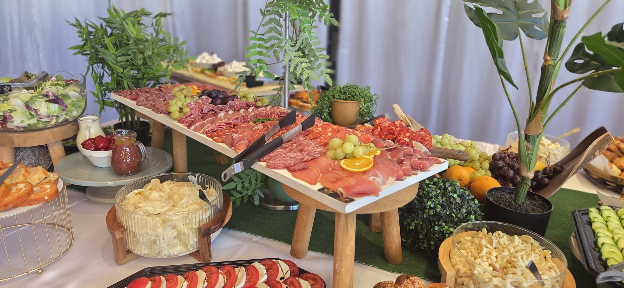 Reichhaltiges Buffet mit Fleisch, Salaten und Früchten